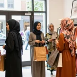Shoppers at a hijabi store exploring stylish outfits and accessories, vibrant fashion and community.